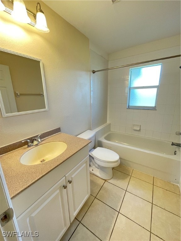 full bathroom with tile patterned floors, vanity, tiled shower / bath combo, and toilet