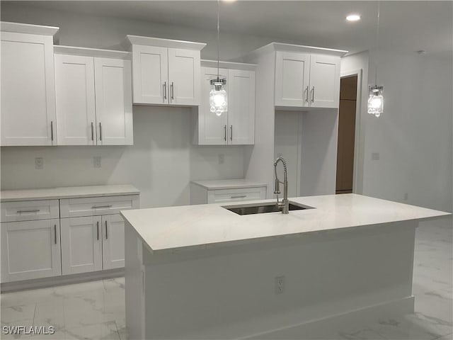 kitchen with white cabinets, pendant lighting, a center island with sink, and sink