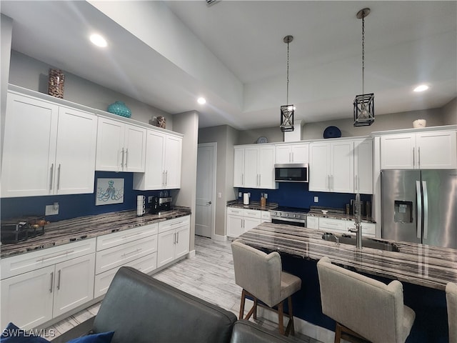 kitchen with light hardwood / wood-style flooring, sink, appliances with stainless steel finishes, and white cabinetry