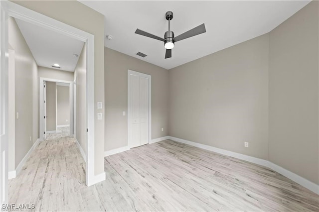 unfurnished bedroom featuring ceiling fan, a closet, and light hardwood / wood-style floors