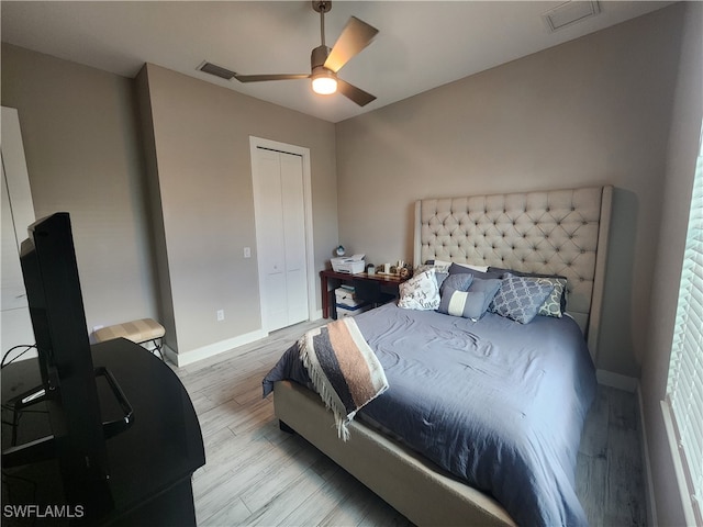 bedroom featuring light wood-type flooring, ceiling fan, and a closet