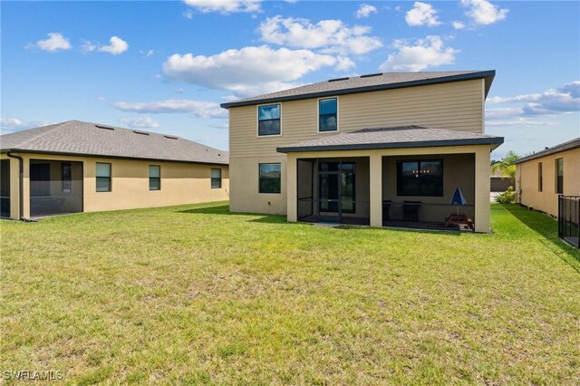 back of property with a lawn and a sunroom