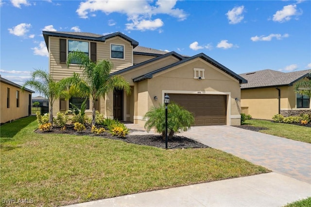 view of front of home featuring a garage, decorative driveway, a front yard, and stucco siding