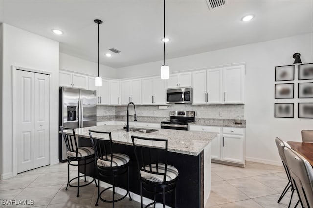 kitchen featuring backsplash, stainless steel appliances, an island with sink, and sink