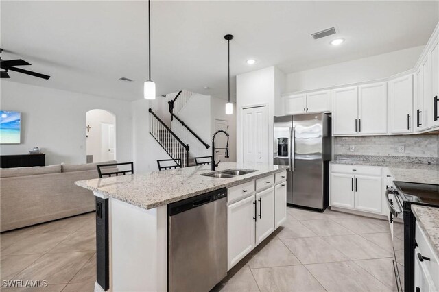 kitchen featuring white cabinets, appliances with stainless steel finishes, a center island with sink, and ceiling fan