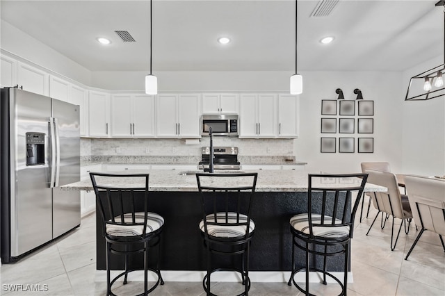 kitchen featuring light stone countertops, light tile patterned floors, and stainless steel appliances