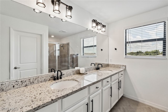 bathroom featuring tile patterned flooring, an enclosed shower, and vanity