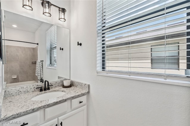 bathroom with tiled shower / bath and vanity