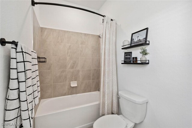 bathroom with toilet and shower / bath combination with curtain