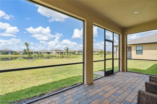 unfurnished sunroom with a water view