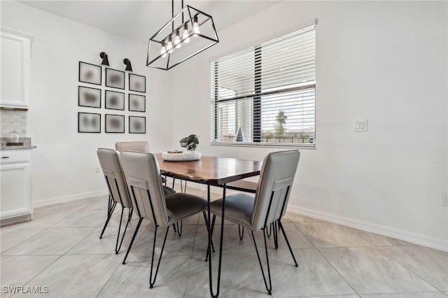 tiled dining room featuring an inviting chandelier