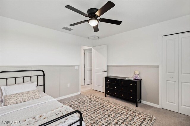 bedroom with light carpet, ceiling fan, and a closet