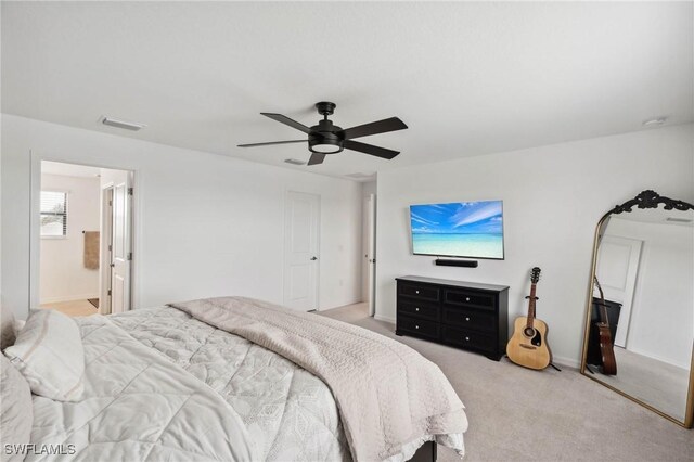 carpeted bedroom with ceiling fan and ensuite bath