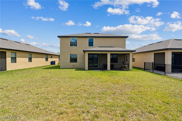 rear view of property featuring a yard and a sunroom