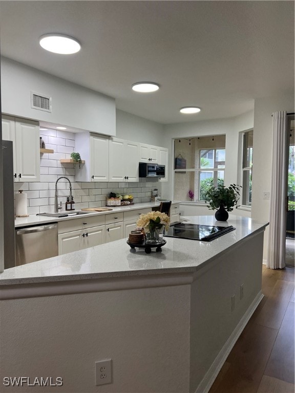 kitchen with dark hardwood / wood-style flooring, stainless steel appliances, sink, and white cabinets