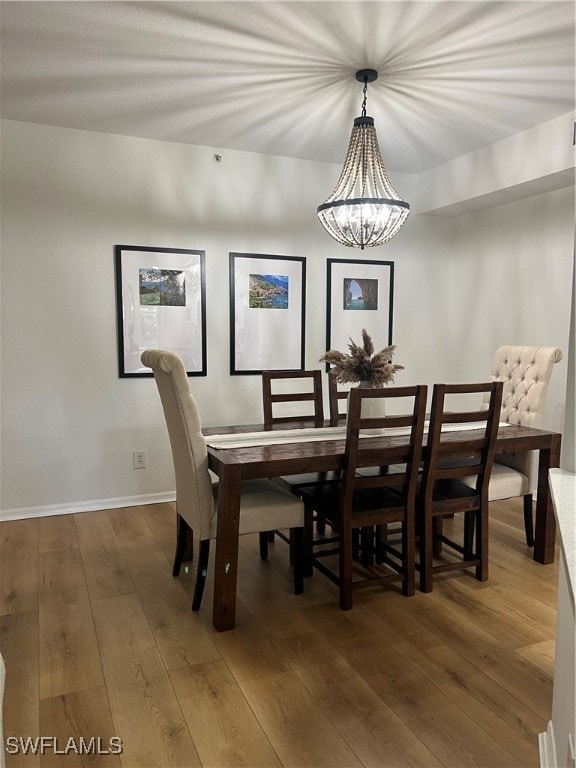 dining area featuring dark hardwood / wood-style floors and an inviting chandelier