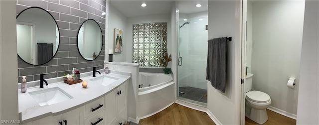 full bathroom with vanity, separate shower and tub, toilet, decorative backsplash, and hardwood / wood-style flooring