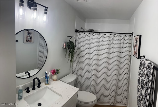 bathroom featuring vanity, toilet, and walk in shower