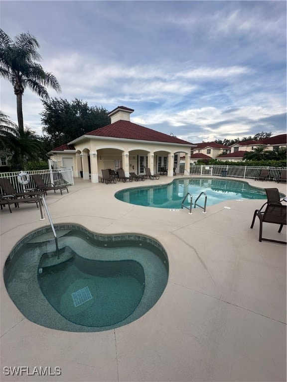 view of pool with a community hot tub and a patio