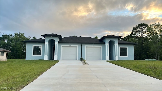 view of front of house with a garage and a lawn