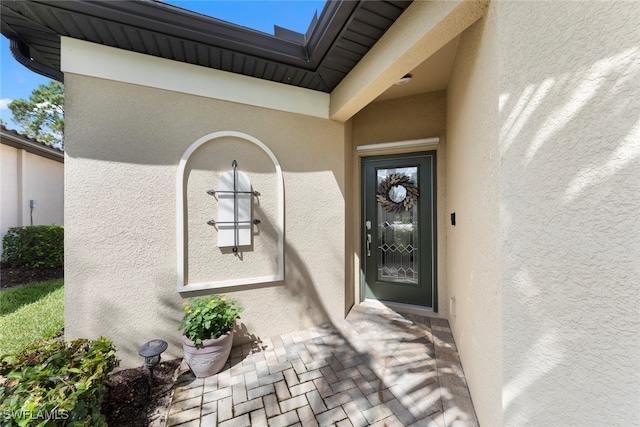 view of exterior entry featuring stucco siding