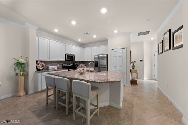 kitchen featuring a breakfast bar, a center island with sink, ornamental molding, a sink, and appliances with stainless steel finishes