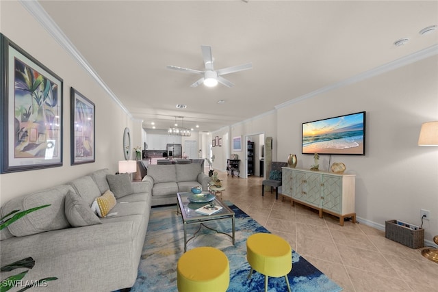 living room with crown molding, light tile patterned floors, ceiling fan with notable chandelier, and baseboards