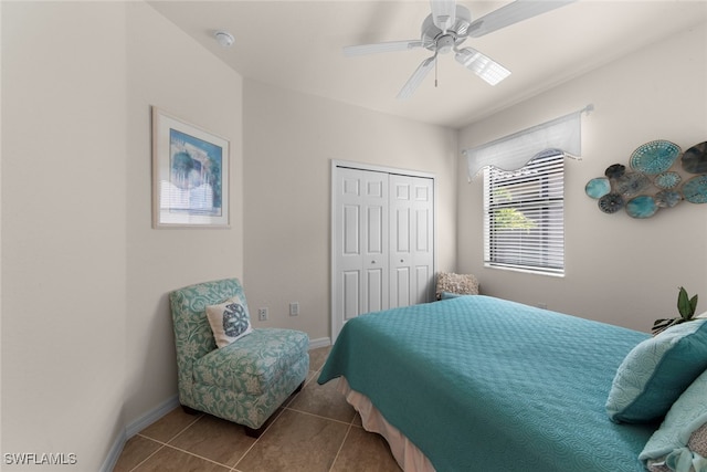 tiled bedroom featuring a closet, baseboards, and a ceiling fan