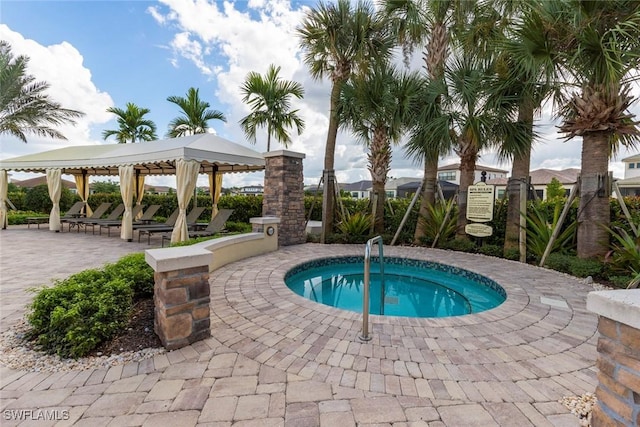 view of pool with a gazebo, a community hot tub, fence, and a patio area