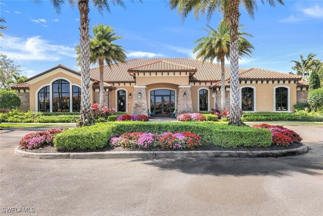 view of front of home featuring a tiled roof, french doors, and stucco siding