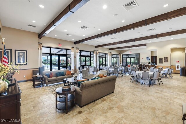 living area featuring beam ceiling and visible vents