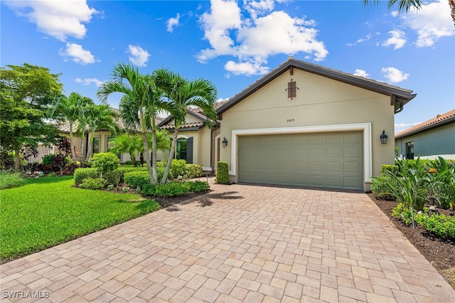 view of front of home featuring a front lawn, decorative driveway, an attached garage, and stucco siding