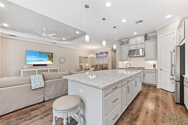 kitchen featuring a center island with sink, visible vents, open floor plan, stainless steel appliances, and under cabinet range hood