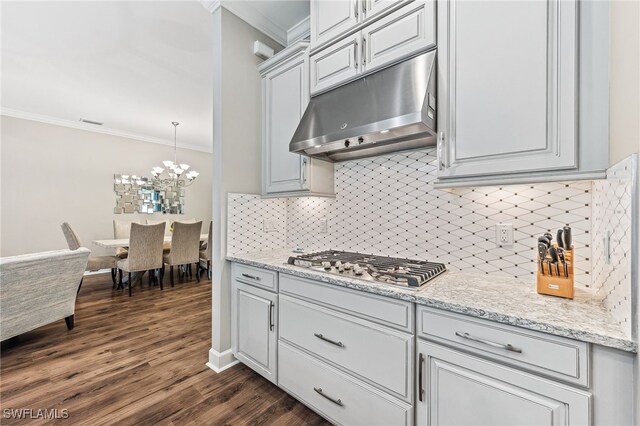 kitchen with dark wood-style floors, decorative light fixtures, stainless steel gas cooktop, crown molding, and under cabinet range hood