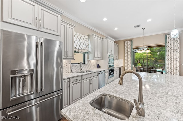 kitchen featuring visible vents, ornamental molding, stainless steel appliances, and a sink