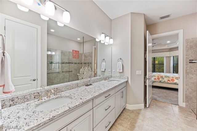 ensuite bathroom featuring ensuite bathroom, double vanity, a sink, and visible vents