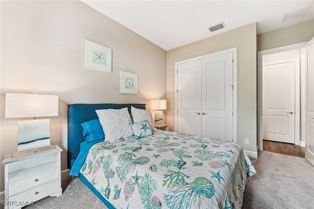 carpeted bedroom with visible vents and a closet