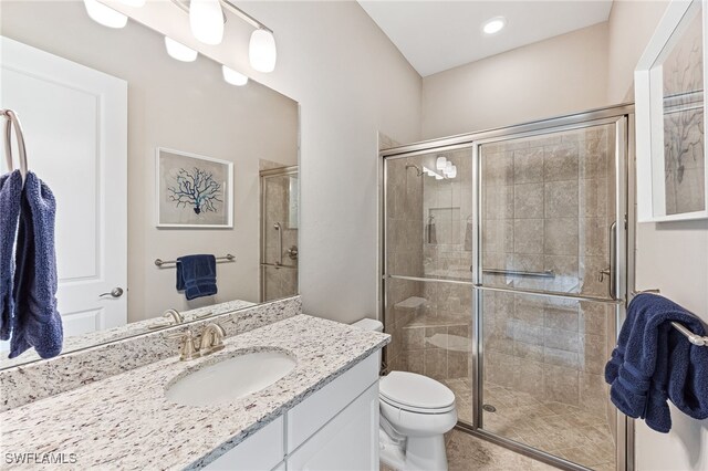 bathroom featuring a stall shower, vanity, and toilet