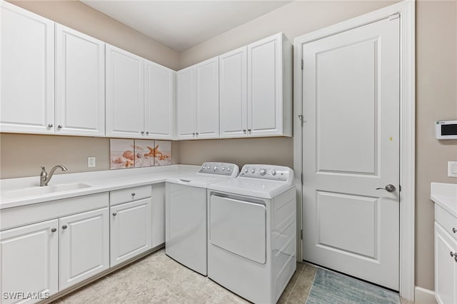 laundry room featuring separate washer and dryer, cabinet space, and a sink