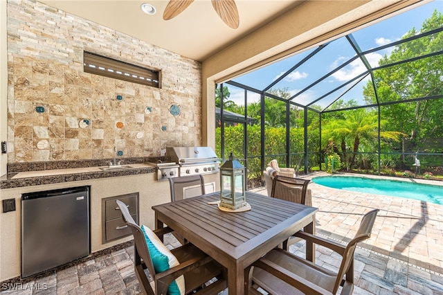 view of patio / terrace with a lanai, area for grilling, and ceiling fan