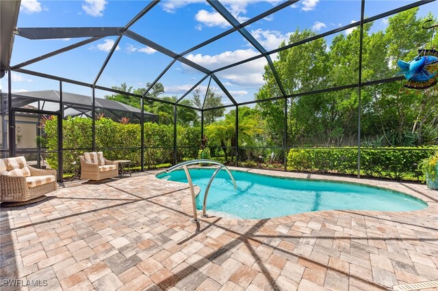 outdoor pool with a lanai, a patio area, and outdoor lounge area