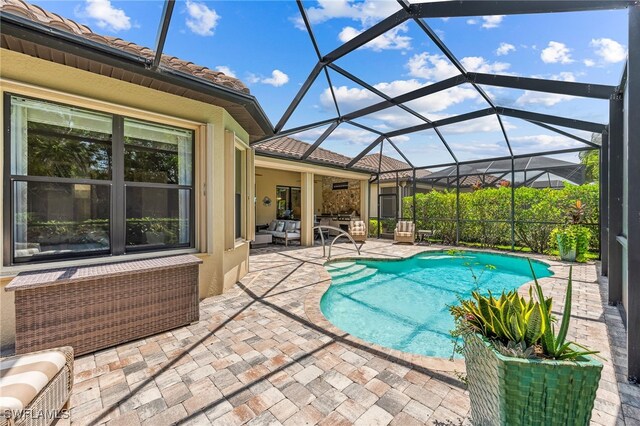 outdoor pool featuring a patio area, ceiling fan, glass enclosure, and an outdoor living space