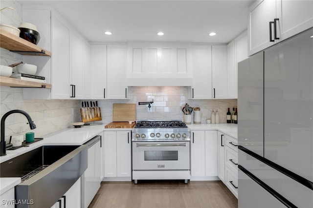 kitchen featuring stainless steel appliances, white cabinetry, sink, and light wood-type flooring