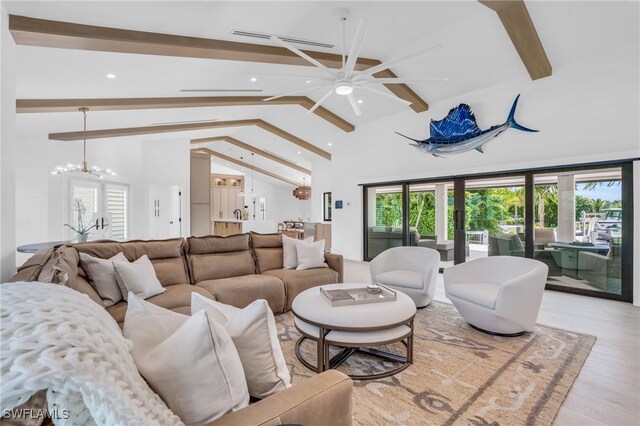 living room with light wood-type flooring, beamed ceiling, high vaulted ceiling, and ceiling fan with notable chandelier