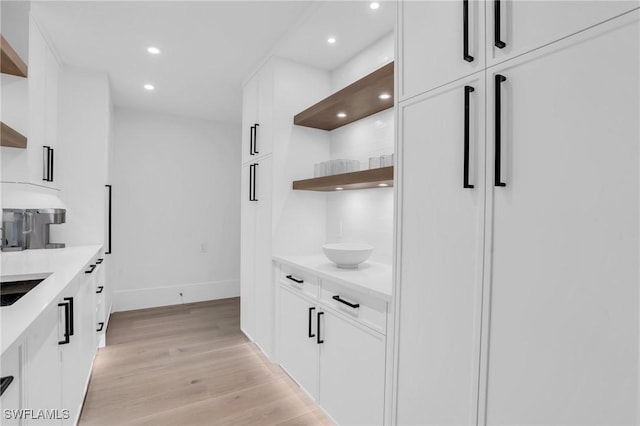 kitchen featuring light countertops, light wood-type flooring, white cabinetry, open shelves, and recessed lighting