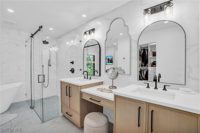 bathroom featuring a marble finish shower, marble finish floor, vanity, a freestanding tub, and tile walls