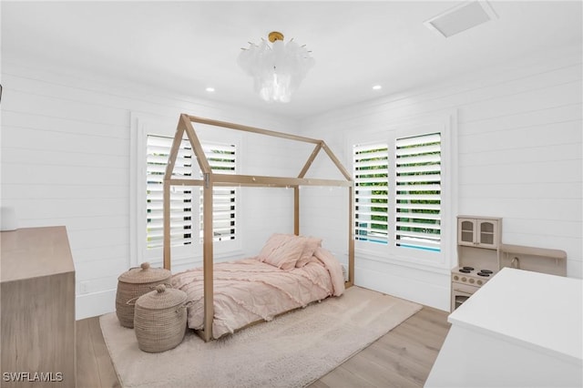 bedroom with light wood-style flooring and visible vents