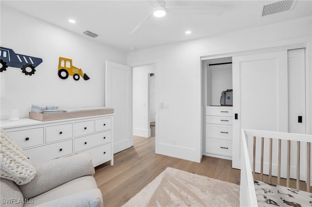 bedroom featuring baseboards, light wood-style flooring, visible vents, and a closet