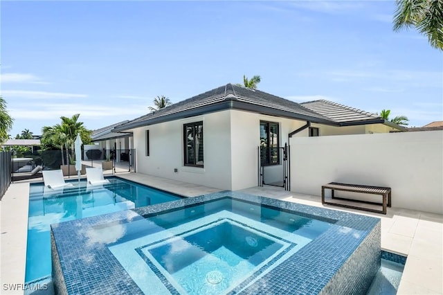 view of pool featuring a patio area, a pool with connected hot tub, a gate, and fence