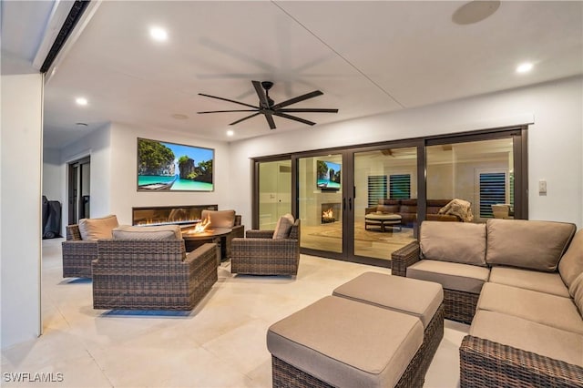 view of patio / terrace featuring a ceiling fan and an outdoor living space with a fire pit